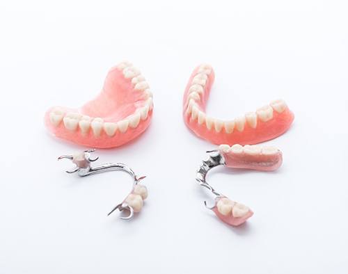 Types of dentures set against a gray background