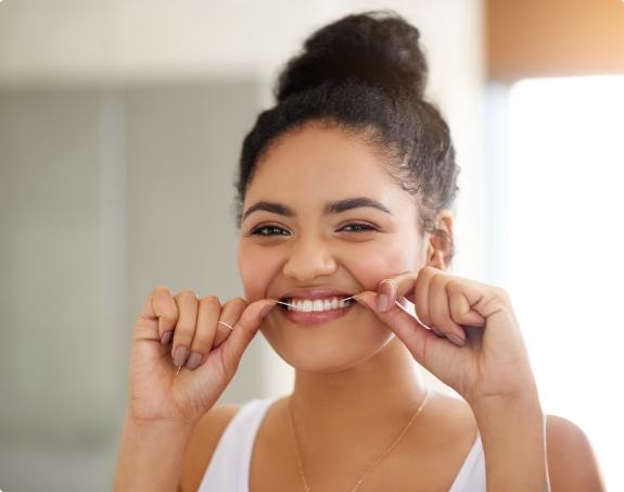 Woman flossing teeth to prevent dental emergencies