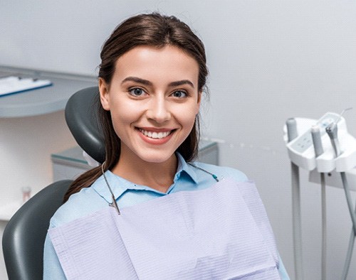 Woman sitting in dental chair and smiling
