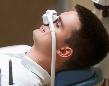 Patient relaxing while breathing in nitrous oxide in treatment chair