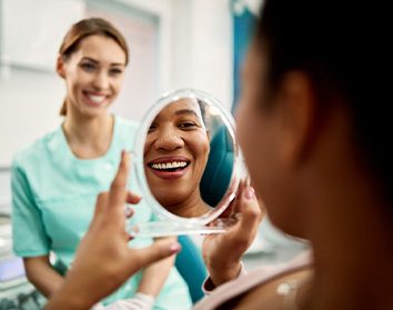 Patient smiling at reflection in treatment chair