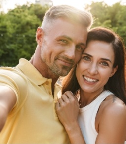 Man and woman sharing aligned smiles after orthodontics treatment