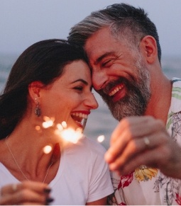 Couple smiling after replacing missing teeth