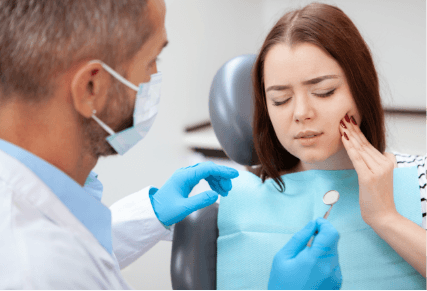 A woman receiving a dental check-up from a dentist in a clinical setting.