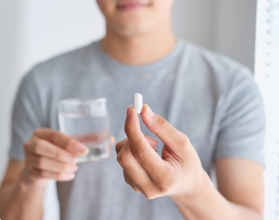 Dental patient holding an oral conscious sedation dentistry pill