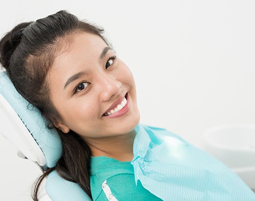 Happy, smiling dental patient in treatment chair