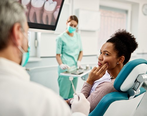 Patient with toothache looking at dentist in treatment chair