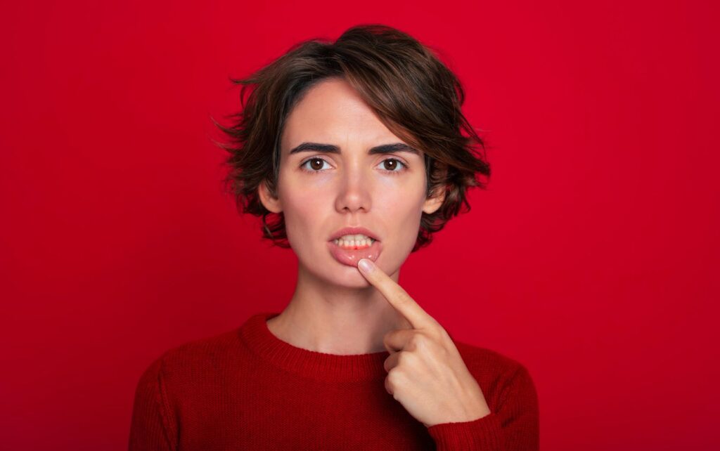 A woman pointing to her gums